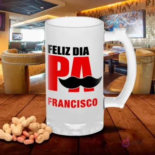 Jarra cervecera esmerilada con diseño 'FELIZ DÍA PA FRANCISCO' en letras grandes rojas y negras con bigote, sobre mesa de madera con cacahuetes, fondo de bar. Plantilla sublimación personalizable.