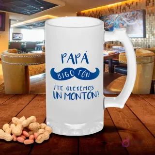 Shoper esmerilado con diseño 'Papá Bigotón ¡Te queremos un montón!' y bigote azul, sobre mesa de madera con cacahuetes, fondo de bar. Plantilla sublimación Papá Bigote.
