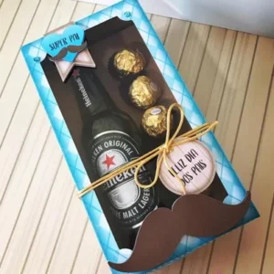 Caja rectangular cerrada con ventana, con una botella de cerveza Heineken y tres chocolates Ferrero Rocher, decorada con un gran bigote y etiqueta 'Feliz Día dos Pais'.