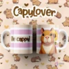 Par de tazas blancas sublimadas con diseño de capibara sonriente con una flor amarilla en la oreja y rayas rosas, texto 'Be cappy!' y 'CapyLover'