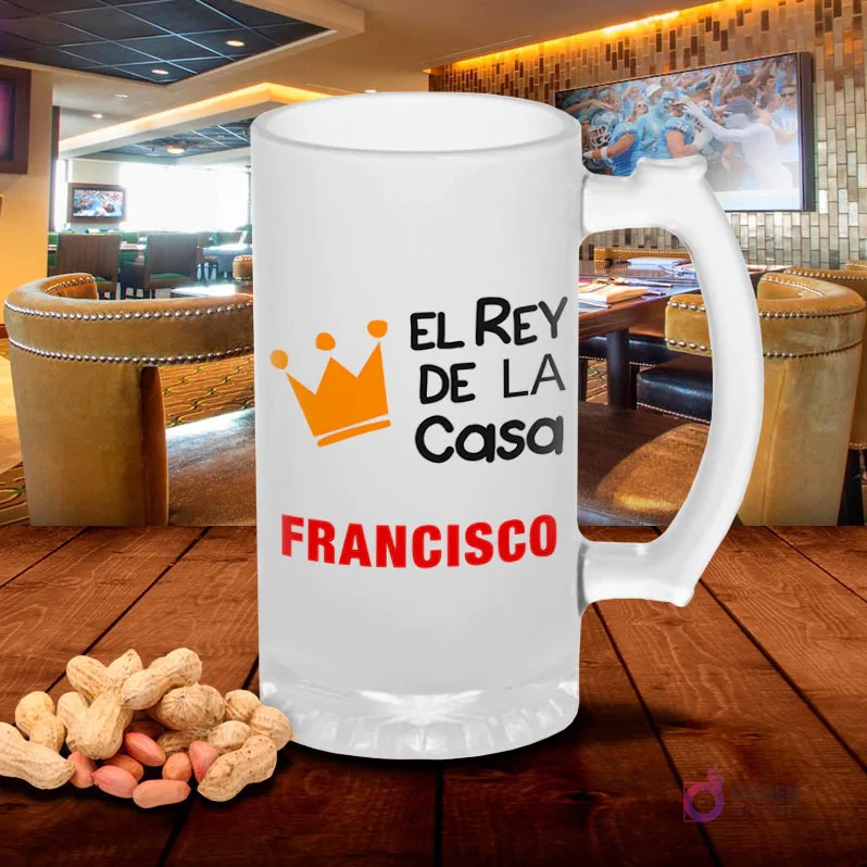 Chopero de vidrio esmerilado con diseño 'El Rey de la Casa FRANCISCO' con corona naranja, sobre mesa de madera con cacahuetes, fondo de bar. Plantilla sublimación Rey de la Casa. Chopero de vidrio esmerilado con diseño 'El Rey de la Casa FRANCISCO' con corona naranja, sobre mesa de madera con cacahuetes, fondo de bar. Plantilla sublimación Rey de la Casa.