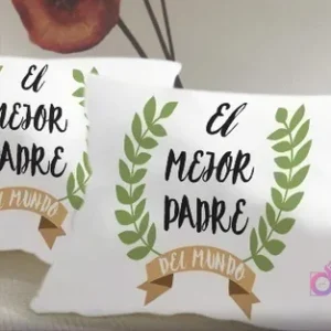 Cojines blancos con un diseño sublimado que reza 'El mejor padre del mundo' enmarcado por laureles verdes y una cinta marrón, ideal para reconocer a papá.