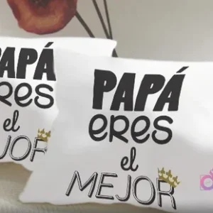 Dos cojines blancos con diseño sublimado 'Papá eres el MEJOR' en tipografía negra impactante con una pequeña corona dorada, mostrando la calidad del estampado.