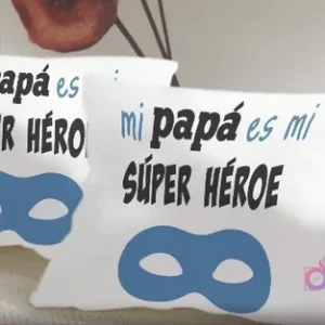 Cojines de sublimación blancos con el diseño 'Mi papá es mi SÚPER HÉROE' en tipografía negra y azul, acompañado de una máscara de superhéroe azul, perfecto para niños.