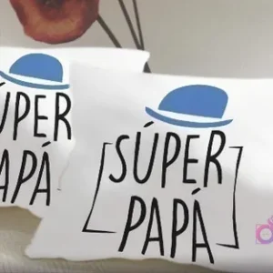Dos cojines blancos personalizados con el diseño 'SÚPER PAPÁ' en tipografía moderna y un sombrero azul.