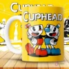 Mockup de taza amarilla con diseño de Cuphead y Mugman sonrientes, brazos entrelazados, y logo 'Cuphead'.