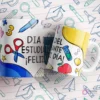Mug blanco y azul con tijeras, lápiz, mochila y la frase 'Día del Estudiante ¡Feliz Día!'