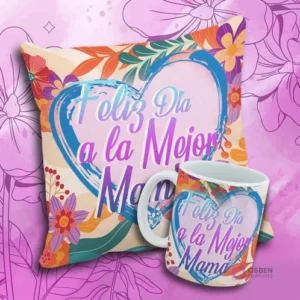 Cojín y taza con el mensaje 'Feliz Día a la Mejor Mama' en un corazón artístico azul y rosa con flores abstractas.