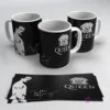 Mugs negros sublimados con diseños de Queen, Freddie Mercury y firma, junto a hojas de sublimación.