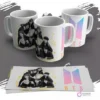 Tres tazas blancas personalizadas con diseños de BTS en blanco y negro, con chaquetas de cuero, y un diseño del logo de BTS en degradado pastel. Se ven las plantillas de los diseños impresas sobre un fondo gris.