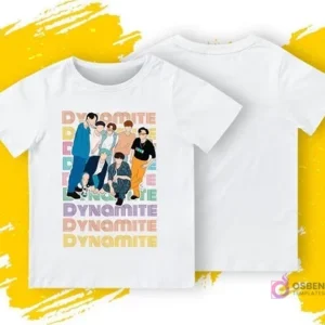 Una polera blanca con una ilustración frontal de los miembros de BTS de la era 'Dynamite' y el texto 'DYNAMITE' repetido. Se muestra la parte delantera y trasera de la polera sobre un fondo amarillo y gris.