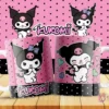 Dos tazas blancas con diseño de Kuromi en fondo rosa con lunares negros y base negra con lunares blancos. Kuromi con lazo azul y calavera en la cabeza en pose coqueta en una taza, y sonriendo con corazones azules en la otra. El logo 'Kuromi' y dos personajes Kuromi pequeños flotan en la parte superior sobre un fondo rosa con lunares negros.