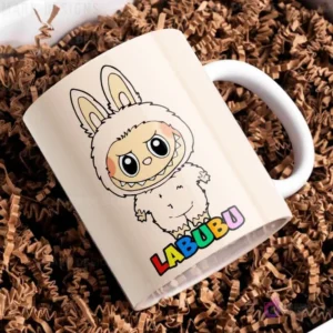 Taza de cerámica beige con diseño del personaje Labubu de traje peludo beige, con el nombre Labubu en letras coloridas, sobre papel picado marrón.