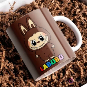 Taza de cerámica marrón oscuro con diseño del personaje Labubu de traje peludo marrón oscuro, con el nombre Labubu en letras coloridas, sobre papel picado marrón.