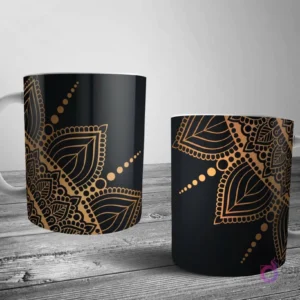 Dos tazas blancas con un lujoso diseño de mandala en oro metálico sobre un fondo negro, ofreciendo un contraste sofisticado y elegante.