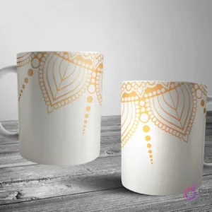 Dos tazas blancas con un elegante diseño de mandala en oro metálico sobre un fondo crema suave, ideal para un estilo sutil y refinado.