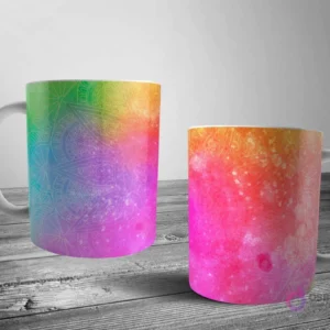 Dos tazas blancas con un patrón de mandala sutil sobre un fondo de arcoíris vibrante y degradado, simulando una explosión de pintura.