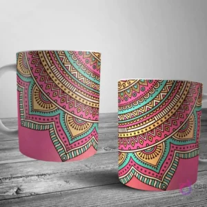 Dos tazas blancas con un intrincado y vibrante diseño de medio mandala en rosa, teal, amarillo y naranja, cubriendo la parte inferior de la taza con un estilo cultural.