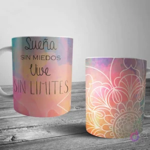 Dos tazas blancas con un diseño de mandala motivacional. Una con la frase 'Sueña SIN MIEDOS Vive SIN LIMITES' y la otra con un mandala de contorno blanco, ambos sobre fondos de acuarela pastel.
