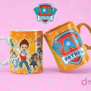 Taza de sublimación blanca con Ryder y varios cachorros de Paw Patrol, junto a una taza naranja con el logo de Paw Patrol, sobre fondo rosa con huellas.