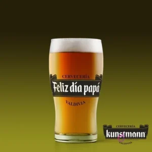 Shopero de cerveza con etiqueta personalizada 'Feliz día papá' al estilo Cervecería Kunstmann, sobre fondo verde oscuro.