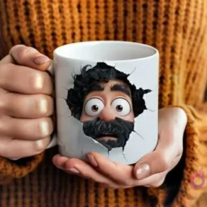 Manos sosteniendo una taza de cerámica blanca con un diseño 3D de un padre barbudo sorprendido emergiendo de la superficie, vistiendo un suéter marrón.