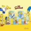 Mockups de tazas con diseños de la familia Simpson: Homer, Marge, Bart, Lisa y Maggie, sobre fondo amarillo y celeste.