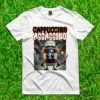 Camiseta blanca con diseño de 'Cappuccino Assassino', una taza de café ninja con espadas frente a un templo japonés y una luna llena.