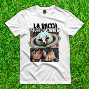 Camiseta blanca con diseño de 'La Vacca Saturno Saturnita', una vaca con la cabeza dentro de un planeta Saturno y pies humanos, caminando en una calle de ciudad.