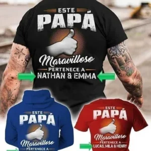 Hombre de espaldas vistiendo polera negra personalizada con el texto 'Este Papá Maravilloso pertenece a Nathan & Emma', junto a un hoodie azul y una polera roja con diseños personalizables similares para el Día del Padre.