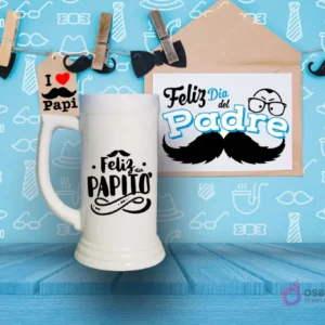 Shoperos blanco con diseño de sublimación 'Feliz Papito' en negro con detalles de bigote y adornos, sobre fondo azul de mesa de madera.
