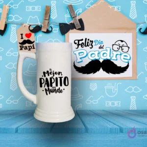 Shoperos blanco con diseño de sublimación 'El Mejor Papito del Mundo' en negro con detalles decorativos, sobre fondo azul con patrones de hombres.