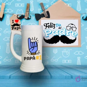 Shoperos blanco con diseño de sublimación 'PAPÁ #1' en colores azul, amarillo y negro con una mano haciendo el signo de 'número uno', sobre fondo del Día del Padre.