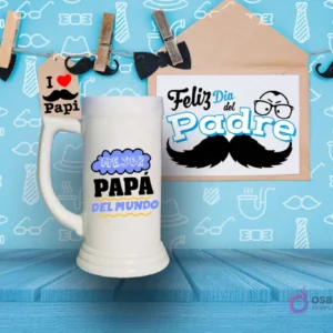 Shoperos blanco con diseño de sublimación 'MEJOR PAPÁ DEL MUNDO' en forma de nube azul y letras amarillas y negras, sobre fondo azul con motivos de corbatas y sombreros.