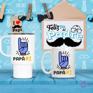 Taza de viaje y taza estándar blancas con diseño 'PAPÁ #1' y mano haciendo 'número uno', sobre fondo azul decorativo.
