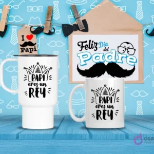 Taza de viaje y taza estándar blancas con diseño 'PAPI eres un REY' en negro con una corona, sobre fondo azul de patrones y madera.