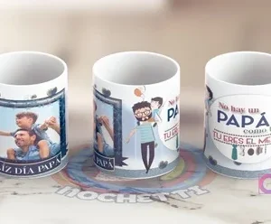 Tazas del Día del Padre con diseños en tonos azules: una con marco de foto, otra con papá y niño al hombro, y una tercera con mensaje 'No hay un PAPÁ como tú TU ERES EL MEJOR' y elementos cotidianos.