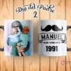Taza de sublimación Día del Padre con ilustración de papá sosteniendo a su hijo y "Día del Padre 2" en la imagen. El reverso de la taza muestra un bigote estilizado y texto personalizable "MANUEL MEJOR PADRE DESDE 1991".
