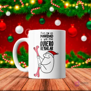 Taza de sublimación blanca con Flork con gorro de Santa intentando ponerse medias navideñas, texto 'Aún no es NAVIDAD y ya me QUIERO REGALAR' con fondo navideño rojo.