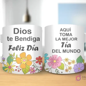 Taza de sublimación con diseño floral, texto 'Dios te Bendiga Feliz Día' y 'AQUÍ TOMA LA MEJOR Tía DEL MUNDO' con asa blanca.