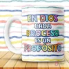 Taza blanca con mensaje cristiano 'En Dios cada proceso es un propósito' en letras coloridas sobre fondo de rayas vibrantes