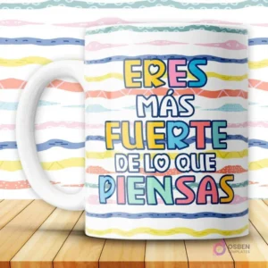 Taza blanca con mensaje motivacional 'Eres más fuerte de lo que piensas' en letras coloridas sobre fondo de rayas vibrantes