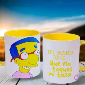 Dos tazas blancas con asas amarillas, mostrando a Milhouse de Los Simpsons en una y la frase 'Mi mamá dice... Que no toques mi taza' en la otra, contra un fondo de atardecer en el campo.