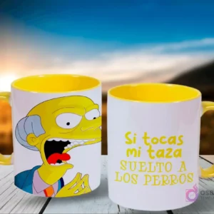 Un par de tazas de Los Simpsons, blancas con el interior amarillo, con el Sr. Burns asustado en una y la frase 'Si tocas mi taza suelto a LOS PERROS' en la otra, frente a un cielo azul y montañas.