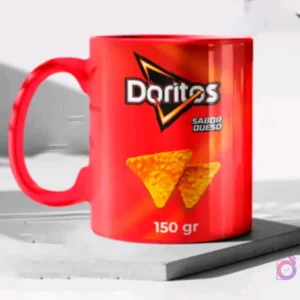Taza de cerámica color rojo brillante sublimada con el diseño de papas Doritos sabor queso, en un mockup sobre una base gris clara.