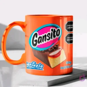 Taza de cerámica color naranja brillante sublimada con el diseño del pastelito Gansito de Marinela y sus etiquetas de advertencia, en un mockup.