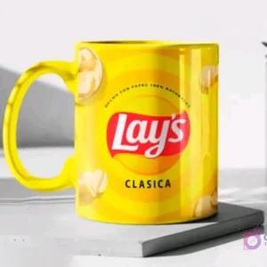 Taza de cerámica color amarillo brillante sublimada con el diseño de papas Lay's Clásica, en un mockup sobre una base gris clara.