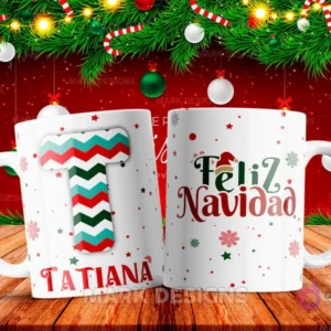 Taza sublimada con la letra T mayúscula en rayas rojas, verdes y turquesas, similar a una bufanda, junto al nombre 'TATIANA' y al reverso 'Feliz Navidad' con estrellas y copos de nieve.