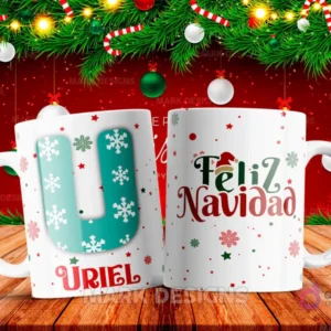 Taza sublimada con la letra U mayúscula en turquesa adornada con copos de nieve, junto al nombre 'URIEL' y al reverso 'Feliz Navidad' con estrellas y copos de nieve.
