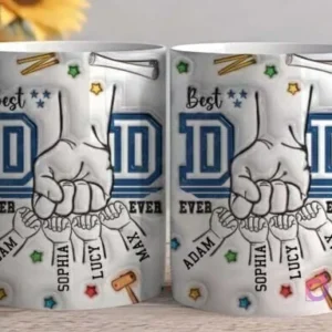 Primer plano de dos tazas blancas sublimadas con el diseño 'Best DAD EVER', destacando el puño de un padre y cuatro manos de niños con nombres como 'Adam', 'Sophia', 'Lucy', 'Max' y herramientas dispersas en el fondo del diseño, sobre una mesa de madera.